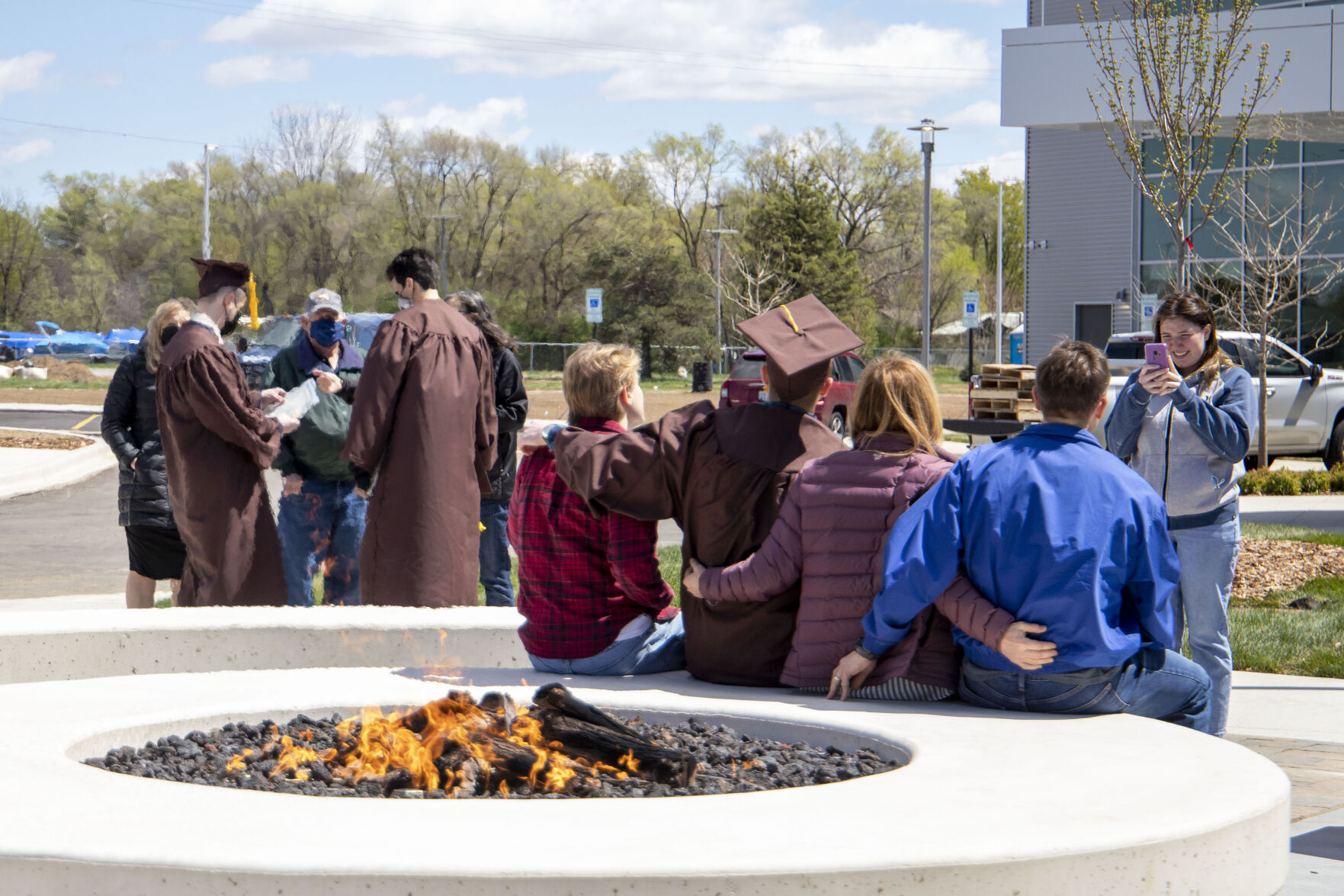 A graduate and their family gather for a picture outside of the new College of Aviation building.